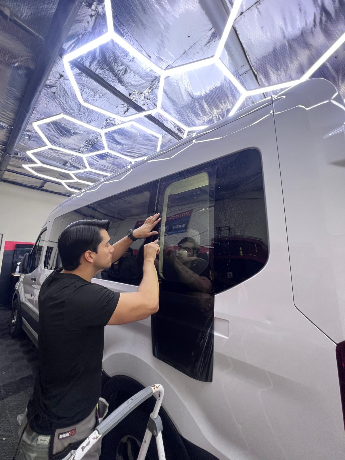 Nogales Window Tint technician installing window film on a sprinter van